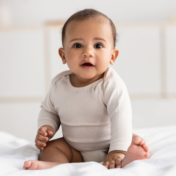 Baby sitting on bed